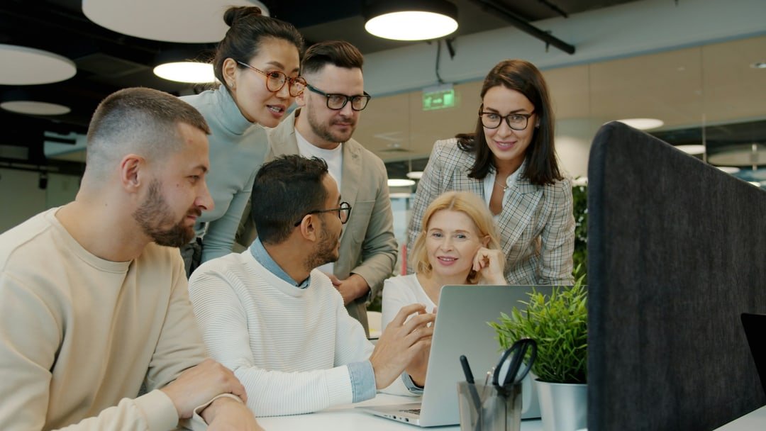 A team of colleagues collaborating around a laptop